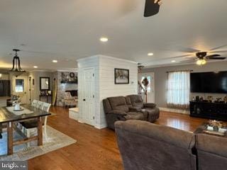 living room featuring dark hardwood / wood-style floors, ceiling fan, and ornamental molding