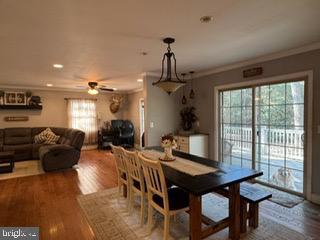 dining space with hardwood / wood-style floors, a wealth of natural light, crown molding, and ceiling fan