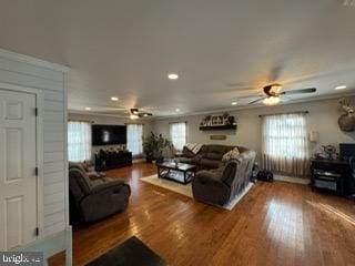 living room featuring hardwood / wood-style flooring, ceiling fan, and a wealth of natural light