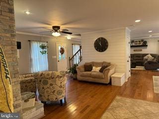 living room with hardwood / wood-style floors, ceiling fan, and ornamental molding