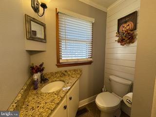 bathroom featuring crown molding, vanity, and toilet