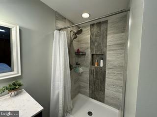 bathroom featuring vanity and curtained shower