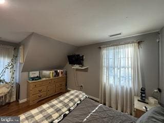 bedroom with dark hardwood / wood-style floors and vaulted ceiling