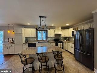 kitchen featuring hanging light fixtures, a kitchen island, black appliances, and custom exhaust hood