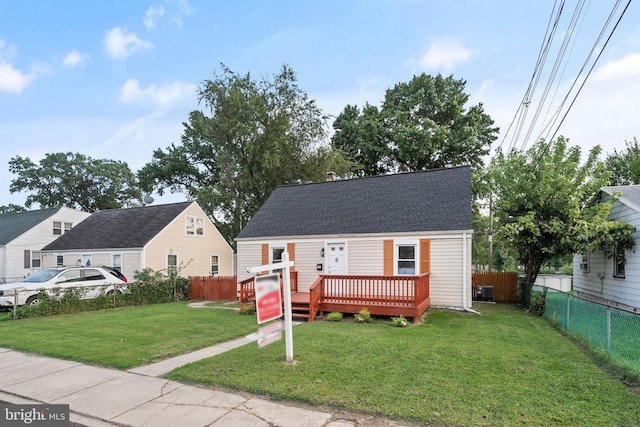 view of front of property with a deck and a front lawn