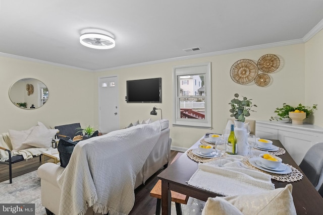 dining space with ornamental molding and wood-type flooring