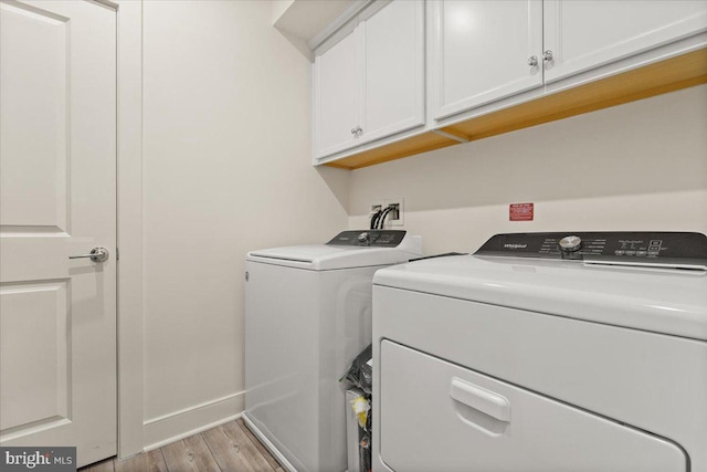 laundry room with light hardwood / wood-style floors, cabinets, and independent washer and dryer