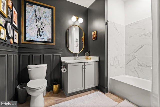 full bathroom featuring hardwood / wood-style floors, vanity, toilet, and shower / tub combination