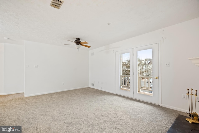 carpeted empty room featuring ceiling fan and a textured ceiling