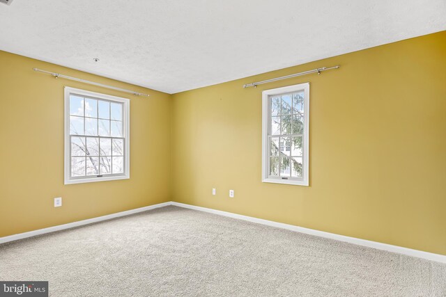 carpeted empty room with a textured ceiling