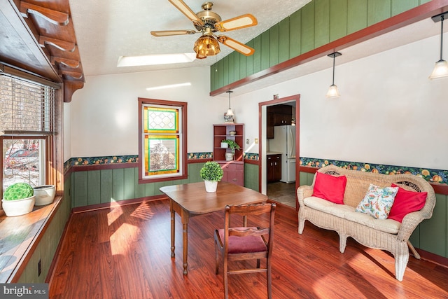 dining area featuring a textured ceiling, dark wood-type flooring, ceiling fan, and lofted ceiling