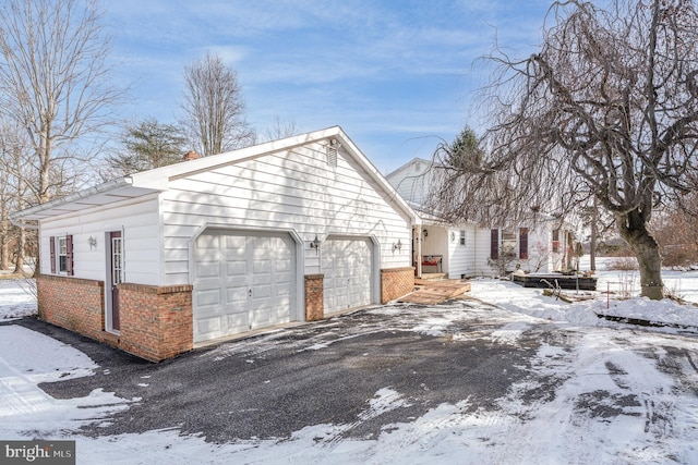 view of snowy exterior with a garage