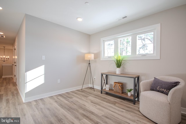 living area with light hardwood / wood-style floors and a chandelier