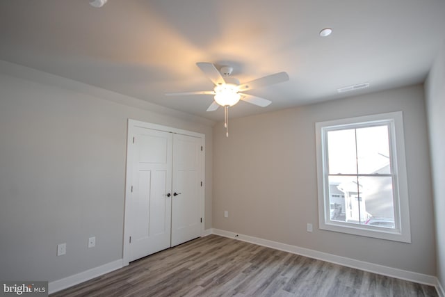 unfurnished bedroom featuring ceiling fan, a closet, and light hardwood / wood-style floors