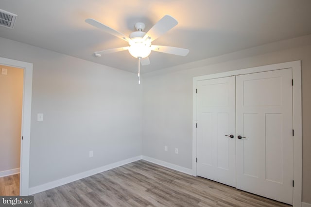 unfurnished bedroom with ceiling fan, a closet, and light hardwood / wood-style floors