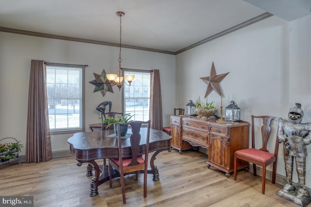 dining area featuring ornamental molding, a chandelier, a healthy amount of sunlight, and light hardwood / wood-style flooring