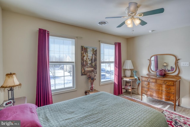 bedroom featuring multiple windows, hardwood / wood-style flooring, and ceiling fan