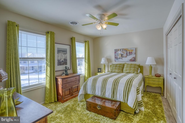 bedroom featuring a closet, ceiling fan, and light colored carpet