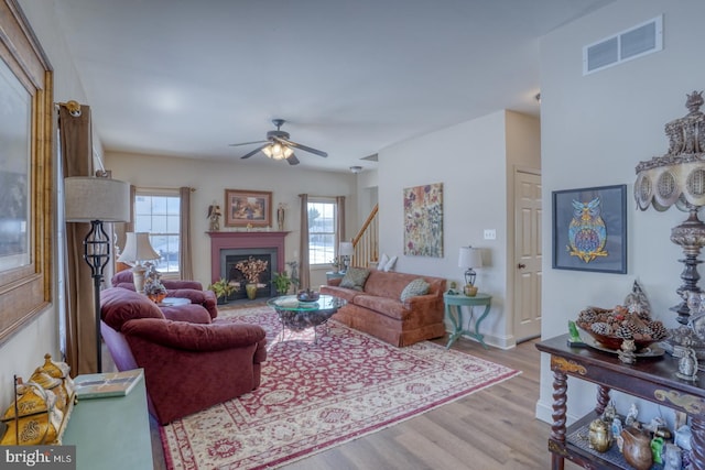 living room featuring ceiling fan, light hardwood / wood-style flooring, and a wealth of natural light