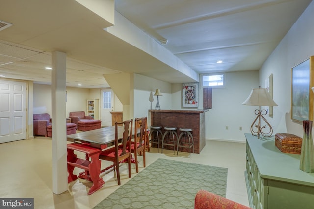 dining area with a drop ceiling and bar