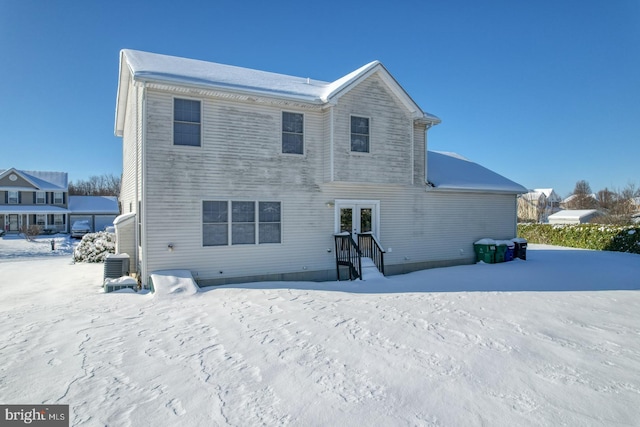 snow covered property featuring central AC unit