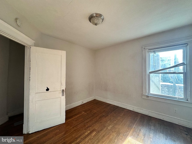 empty room with dark wood-type flooring