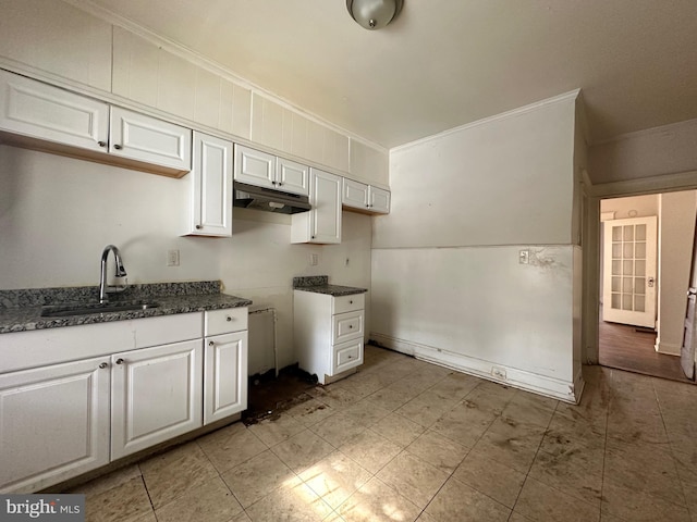 kitchen featuring white cabinetry, crown molding, and sink