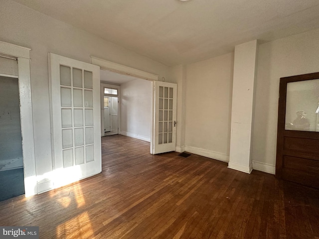 unfurnished room with dark wood-type flooring and french doors