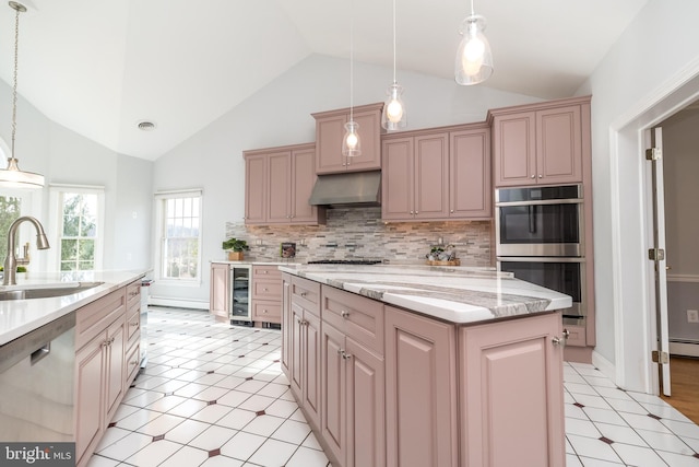 kitchen with lofted ceiling, a kitchen island, sink, hanging light fixtures, and stainless steel appliances