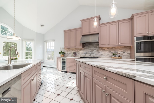 kitchen featuring stainless steel appliances, tasteful backsplash, hanging light fixtures, range hood, and sink