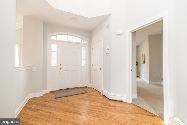 foyer entrance featuring baseboard heating and light hardwood / wood-style flooring