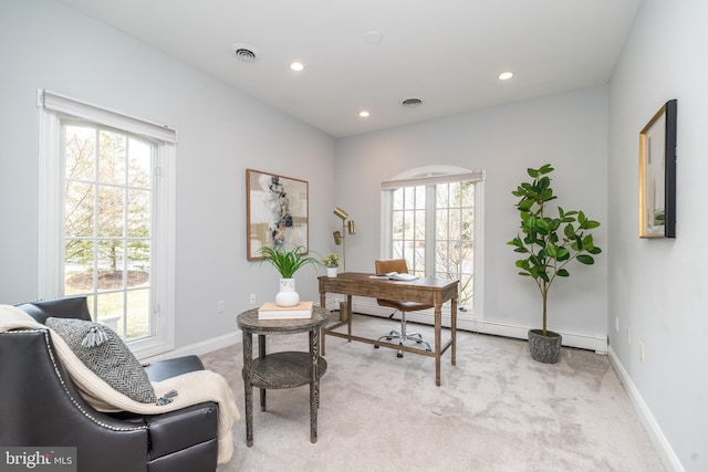 office area with light colored carpet, baseboard heating, and a wealth of natural light