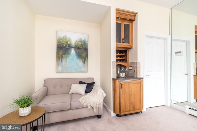 living area with light carpet and a baseboard heating unit