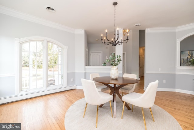 dining space featuring light wood-type flooring, baseboard heating, a chandelier, and crown molding