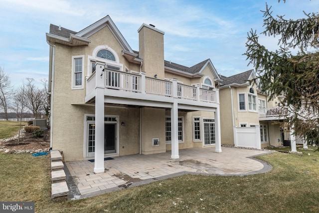 back of house with a balcony, cooling unit, a yard, and a patio