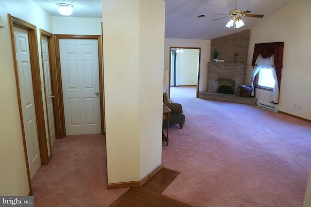 hallway featuring light colored carpet, lofted ceiling, a textured ceiling, and a baseboard heating unit