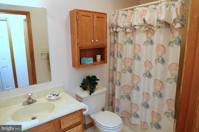 bathroom with vanity, curtained shower, and toilet