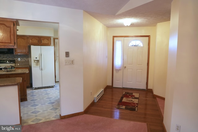 foyer entrance featuring a textured ceiling and baseboard heating