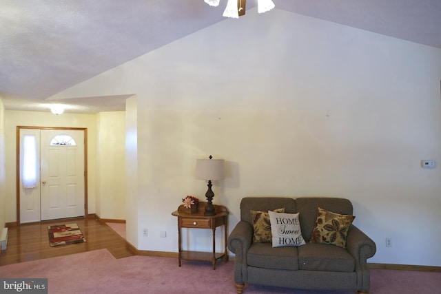 carpeted entrance foyer featuring lofted ceiling