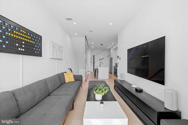 living room featuring sink and light hardwood / wood-style floors