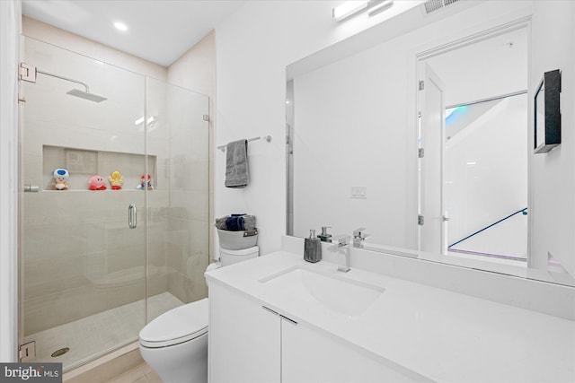 bathroom with vanity, an enclosed shower, and toilet