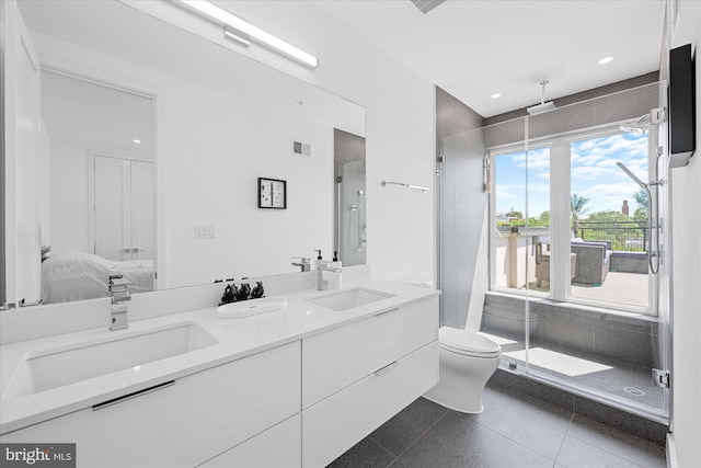 bathroom featuring tile patterned flooring, vanity, toilet, and walk in shower