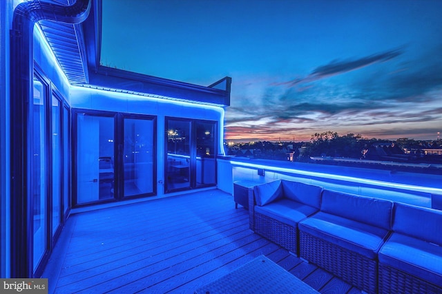 deck at dusk featuring an outdoor hangout area