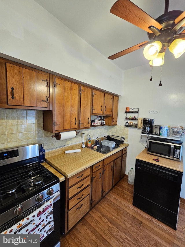 kitchen with gas range, dishwasher, sink, light hardwood / wood-style flooring, and backsplash