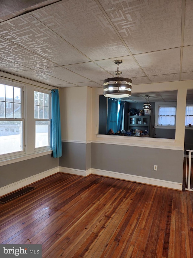 empty room with a chandelier and hardwood / wood-style flooring