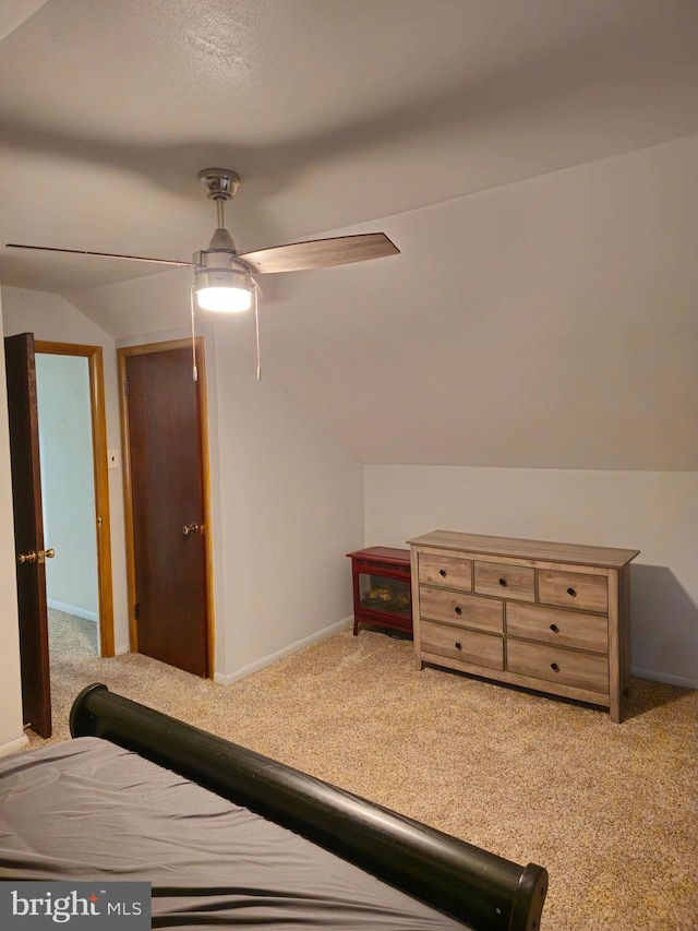 carpeted bedroom featuring ceiling fan and vaulted ceiling