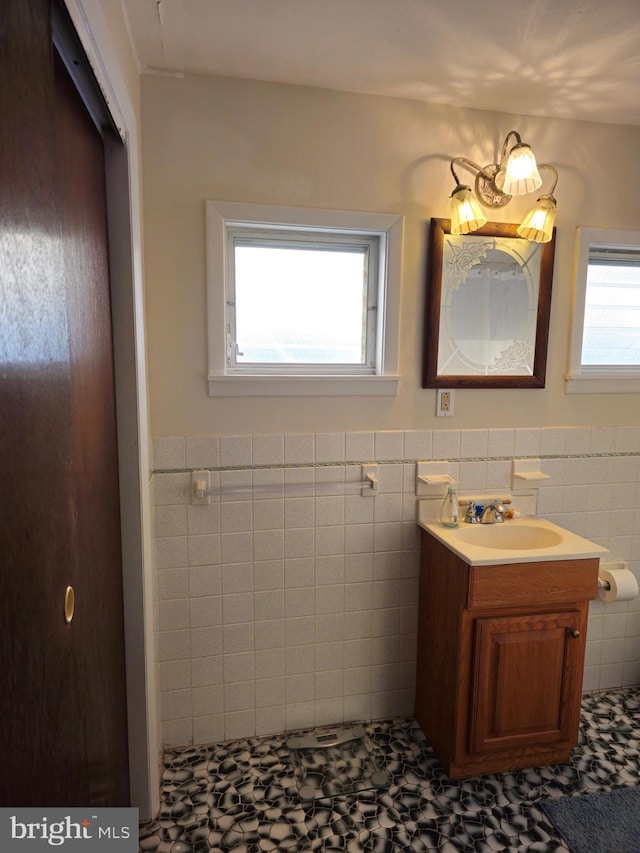 bathroom with vanity and tile walls