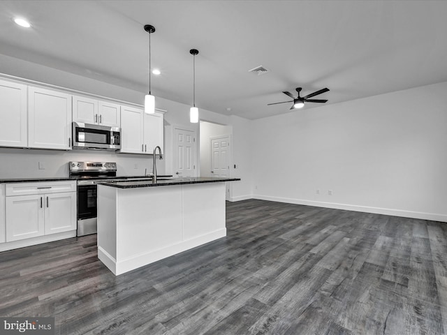 kitchen with white cabinets, appliances with stainless steel finishes, ceiling fan, and an island with sink