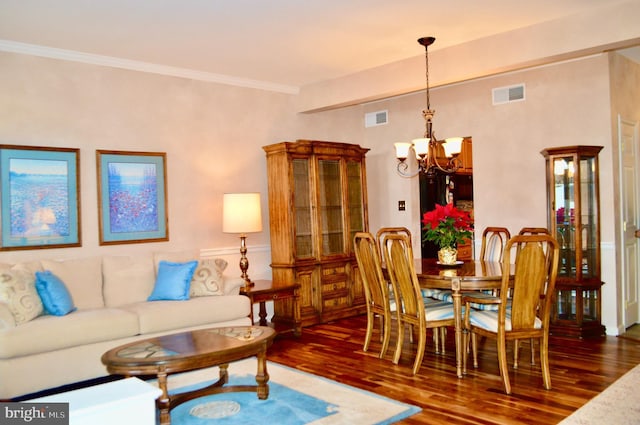 dining room featuring ornamental molding, dark wood-type flooring, and a chandelier