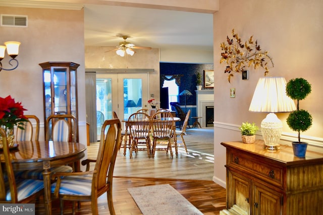 dining space with french doors, light wood-type flooring, and ceiling fan